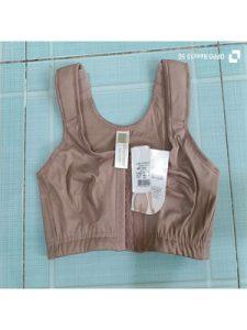 Áo định hình ngực sau thẩm mỹ Latex Ann Chery 5150 màu nâu da, chụp thực tế trên nền gạch xanh.