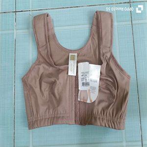 Áo định hình ngực sau thẩm mỹ Latex Ann Chery 5150 màu nâu da, chụp thực tế trên nền gạch xanh.